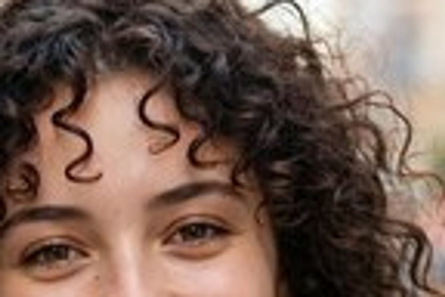 A close-up of a smiling woman's face, enlarged normally